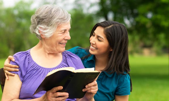 Caregiver helping senior with reading